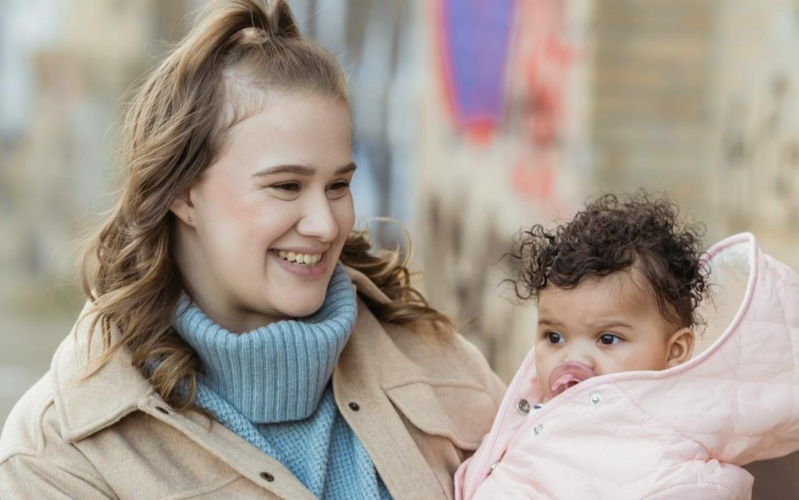 Smiling Mother Carrying Her Baby